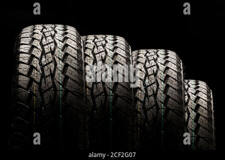 four off-road tires close-up on a black background Stock Photo