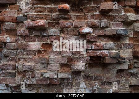 the texture is an old dilapidated wall of vintage weathered brick Stock Photo