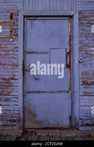 old vintage wooden closed door, purple with peeling paint Stock Photo