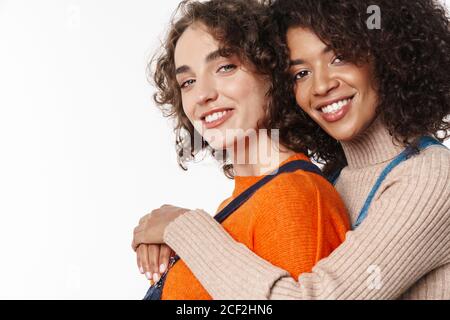 Portrait of smiling multinational women in overalls looking and ...