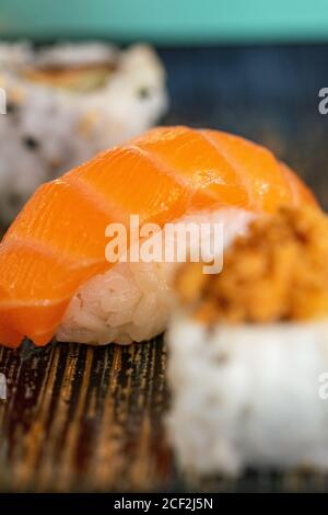 a selection of freshly made sushi rolls served on a blue ceramic plate portrait Stock Photo