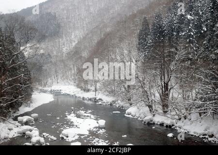 River view from train, in snow, Nishikigawa Seiryu Railway, north Honshu, Japan 16 Feb 2019 Stock Photo