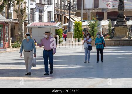 Baeza, Jaen, Spain - June 18, 2020: Elderly people wearing protective or medical face masks during the alarm state and quarantine in Spain. Stock Photo