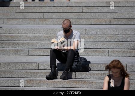 A man reads the book 'Why I'm No Longer Talking To White People About Race' on the steps in Trafalgar Square, London Stock Photo