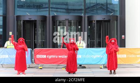 Cardiff, Wales, UK. 3rd Sep 2020. Extinction rebellion protestors outside the BBC on the third day of actions in Cardiff, 3rd September 2020. Protesters urge the BBC to tell the truth and the Red Rebel Brigade pose outside the BBC along with bilingual banners Credit: Denise Laura Baker/Alamy Live News