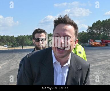 03 September 2020, Brandenburg, Grünheide: Elon Musk, head of Tesla, stands laughing next to journalists at the Tesla Gigafactory construction site. In Grünheide near Berlin, a maximum of 500,000 vehicles per year are to roll off the assembly line from July 2021 - and according to the car manufacturer's plans, the maximum is to be reached as quickly as possible. Photo: Patrick Pleul/dpa-Zentralbild/ZB Stock Photo