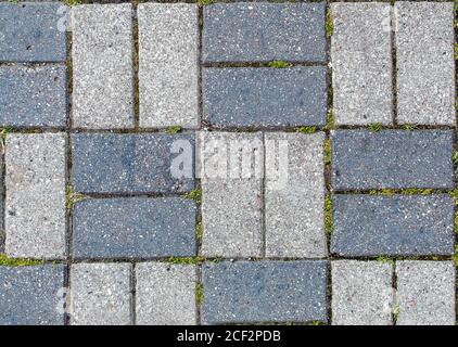 road paved with sidewalk tiles. beautiful brick background with, masonry texture of light and dark gray bricks. outdoor closeup Stock Photo