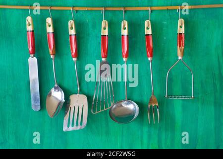 vintage kitchen utensils on grenn painted wall, free copy space Stock Photo