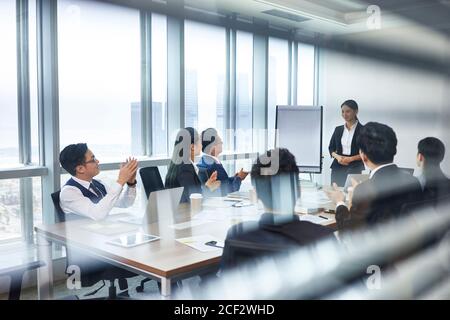 asian new employee introducing self during staff meeting in conference room Stock Photo