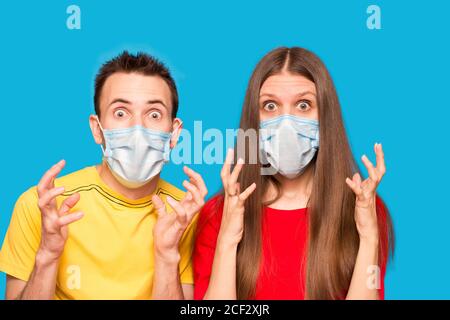 Couple in sterile face mask isolated on blue background studio. Pandemic rapidly spreading coronavirus covid-19 medicine flu virus concept Stock Photo
