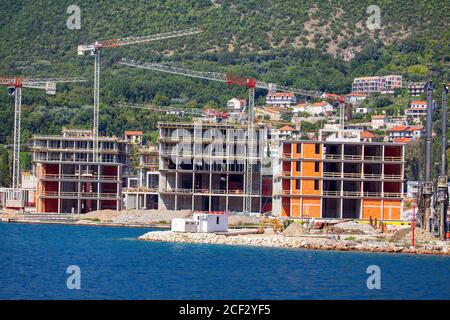 Coastal Construction Site . Construction of new hotels in Kotor Bay . Working cranes Stock Photo