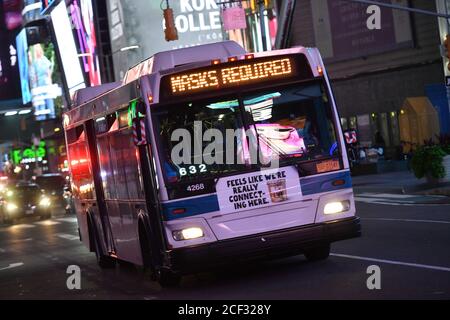 An MTA bus displays a 'MASKS REQUIRED' sign as it drives through Times Square on September 1, 2020 in New York. Stock Photo