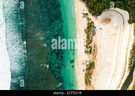 View from above, stunning aerial view of a beautiful beach bathed by a turquoise sea during sunset, Melasti Beach, South Bali, Indonesia. Stock Photo