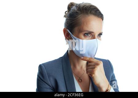 Business during covid-19 pandemic. pensive young female in a grey suit with medical mask against white background. Stock Photo