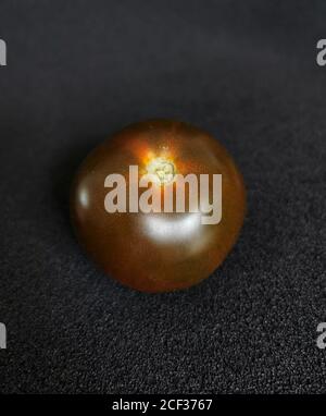 Fresh, dark red heirloom tomato on a black background Stock Photo