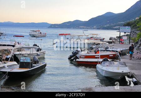 Small rental boats at Nisaki harbour in Corfu seen as the sun sets over the  Greek island. August 2019 Stock Photo