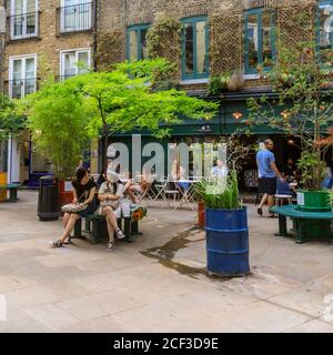 People in Neil's Yard outdoor cafes and pop ups, trendy urban health food and alternative living destination, Covent Garden, London Stock Photo