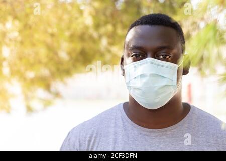 Closeup shot of African American young man wearing face protective medical mask Stock Photo