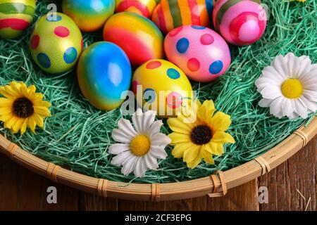 High angle shot of beautifully painted Easter eggs on a decorated basket Stock Photo