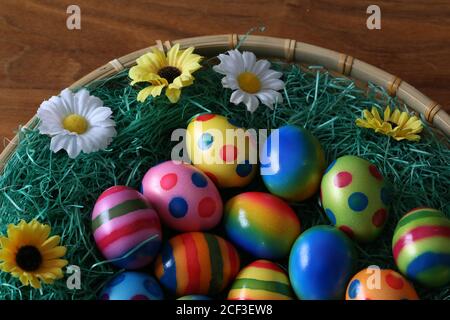 High angle shot of beautifully painted Easter eggs on a decorated basket Stock Photo