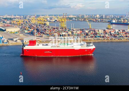 Cargo red ship for the transport of cars and other new transport sails from the port to the sea Stock Photo