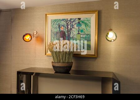 Potted plant on table under painting Stock Photo