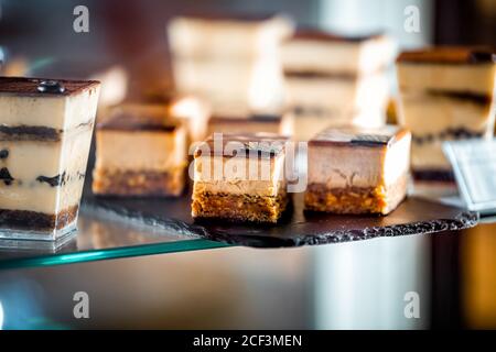 Florence, Italy central market with closeup of chocolate dessert cakes and tiramisu pastries on tray display in bakery shop store Stock Photo
