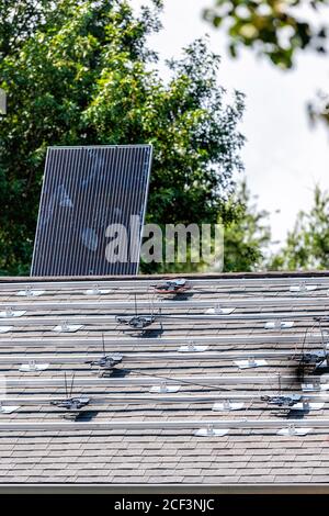 Rooftop installation work of solar panels with racking racks rails mounted on top of house residential home roof for off-grid living in Northern Virgi Stock Photo