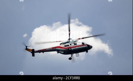 Blurred unrecognizable helicopter in a cloudy sky. Air transport at work Stock Photo