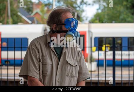 Hampshire, England, UK. 2020.  A male rail traveller wearing medical protective equipment, mask, goggles and gloves during Covid-19 outbreak. Stock Photo
