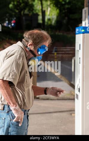 Hampshire, England, UK. 2020. Portrait of a man wearing gloves,  a mask with filter and goggles  during Covid-19 outbreak in the UK.  Purchasing a rai Stock Photo