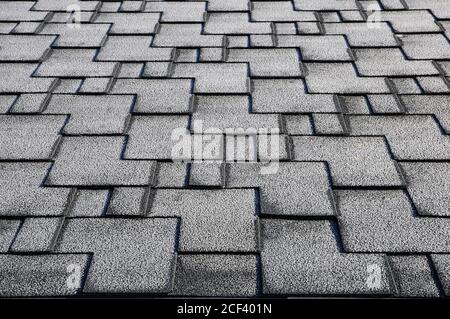 Close up view on asphalt roofing shingles covered with frost. Stock Photo