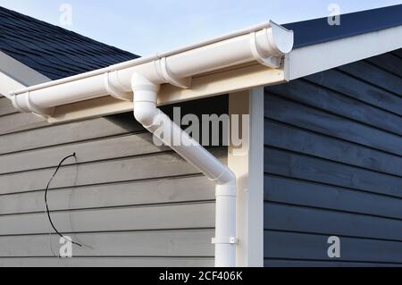 Rain Gutter System and Bitumen Roof Shingles Stock Photo - Alamy