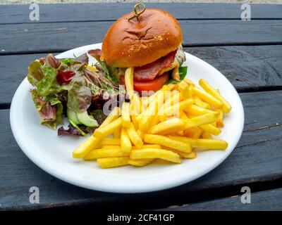 Lord Stones Café  lunch  a  prime Belted Galloway  beef burger  with melted cheddar cheese served outdoors with bacon chips and salad Stock Photo