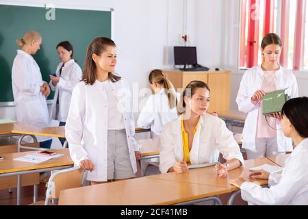 Medical students talking and having fun, spending time together during recess between lectures in auditorium Stock Photo