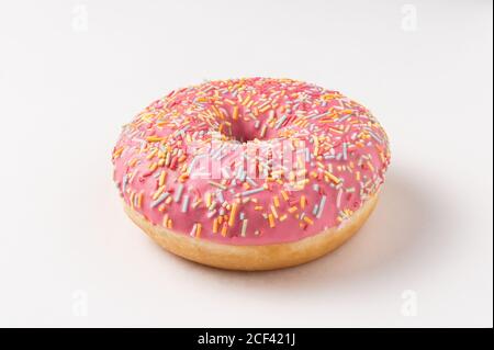 Whole tasty sweet sprinkled pink glazed donuts on white background Stock Photo