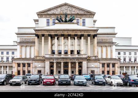 Warsaw, Poland - December 25, 2019: National opera n winter of Warszawa cloudy day exterior facade architecture view and stone columns with cars in pa Stock Photo