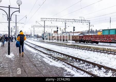 Rivne, Ukraine - December 28, 2019: Train station platform in western Ukrainian city with person people walking outside in winter snow cold weather Stock Photo