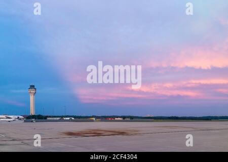 Dulles, USA - June 13, 2018: IAD Dulles International Airport control command center tower with United airplanes during dramatic pink sunset with view Stock Photo