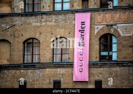 Florence, Italy - August 30, 2018: Sign pink banner on old building facade for Gucci shop store in Firenze Italian city with historic architecture in Stock Photo