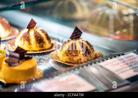 Florence, Italy - August 30, 2018: Firenze Centrale Mercato central market with Beduschi sign closeup of chocolate dessert yellow custard pastries on Stock Photo