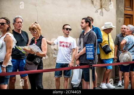 Florence, Italy - August 30, 2018: People standing waiting in line for Firenze Uffizi museum in summer tourists talking Stock Photo