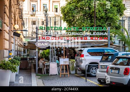 Rome, Italy - September 4, 2018: Historic city on summer day and sign entrance for bar restaurant pizzera with people and cars parked