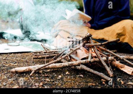 Young female backpacker making notes at campfire Stock Photo