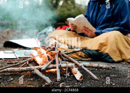 Young female backpacker making notes at campfire Stock Photo