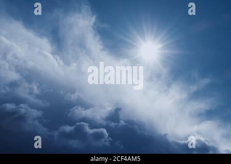 bright natural sun and thunderous dramatic cloud in blue sky Stock Photo