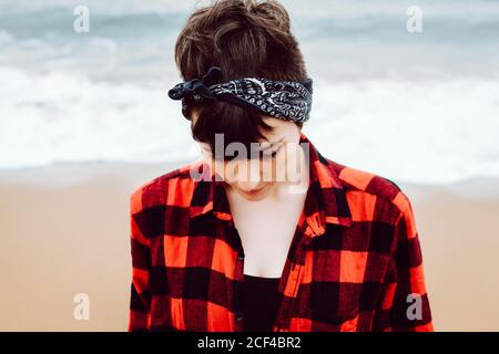 Woman standing on wet sand on beach Stock Photo