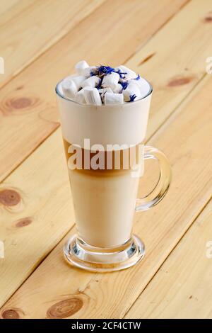 Latte macchiato in tall transparent glass on wooden background Stock Photo