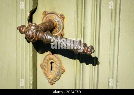 interesting shaped old metal door handle for wooden doors Stock Photo