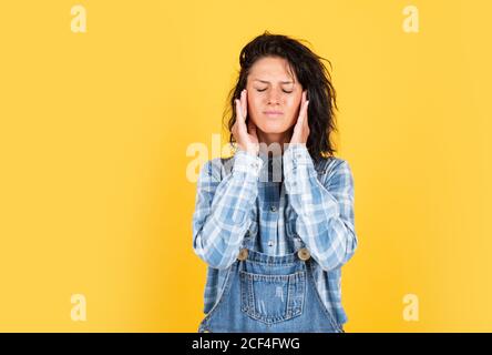 migraine. suffering woman wearing checkered shirt. female beauty and health. concept of healthy living. hipster lifestyle. unhappy woman in denim style. hipster girl has headache. Stock Photo